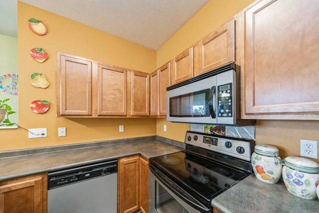 kitchen with dark countertops, appliances with stainless steel finishes, and a textured ceiling