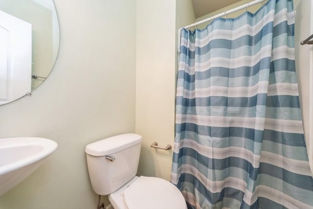 bathroom featuring a shower with shower curtain and toilet