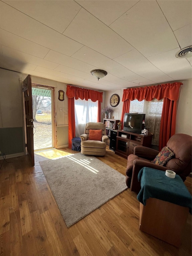 living room featuring visible vents and wood finished floors