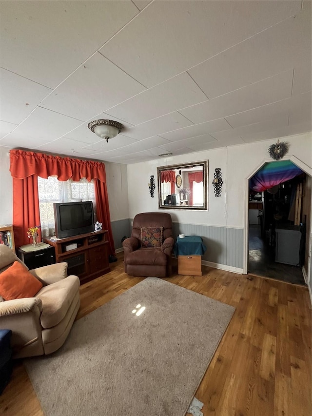 living room featuring a wainscoted wall and wood finished floors