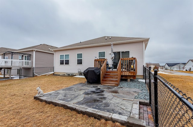 back of property with a deck, a patio area, a yard, and a fenced backyard