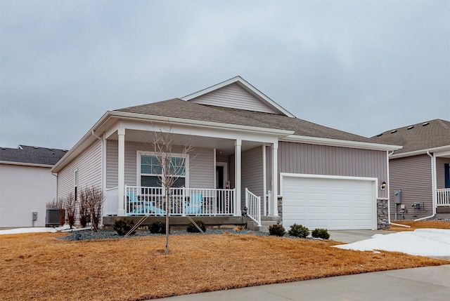 ranch-style home featuring central AC, a porch, roof with shingles, concrete driveway, and an attached garage