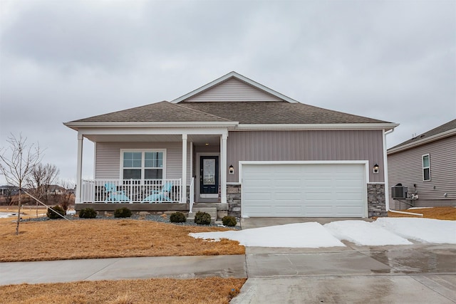 view of front of home with central AC unit, driveway, roof with shingles, a porch, and an attached garage