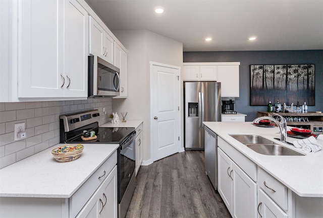 kitchen with dark wood-style flooring, a sink, stainless steel appliances, light countertops, and tasteful backsplash