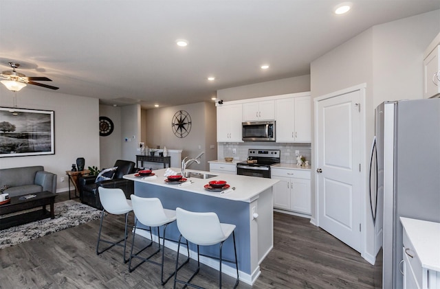 kitchen with backsplash, appliances with stainless steel finishes, open floor plan, and dark wood-style flooring