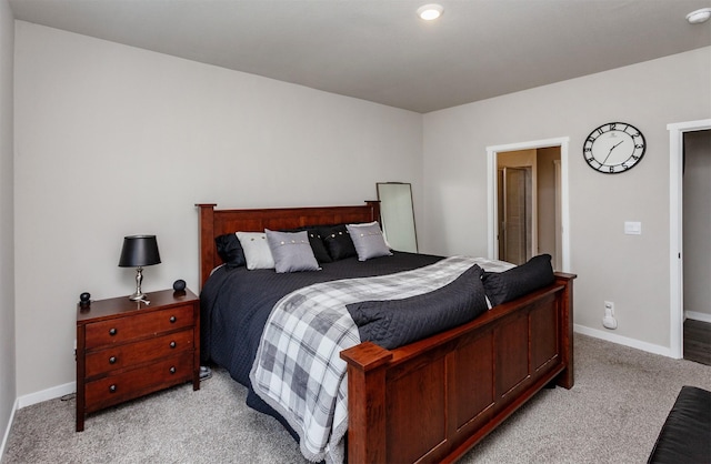 bedroom with baseboards and light carpet