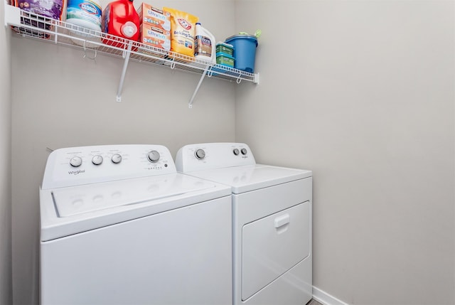 washroom with laundry area, baseboards, and washer and clothes dryer