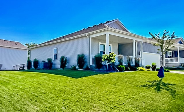 view of property exterior with a yard, a garage, and a porch