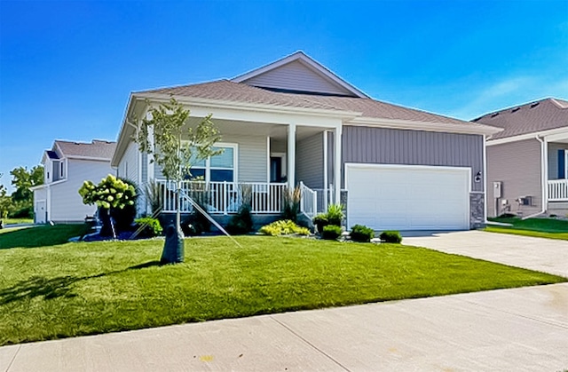 view of front of property with an attached garage, a porch, concrete driveway, and a front yard