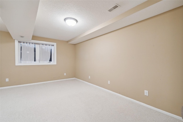 unfurnished room with visible vents, baseboards, a textured ceiling, and carpet flooring