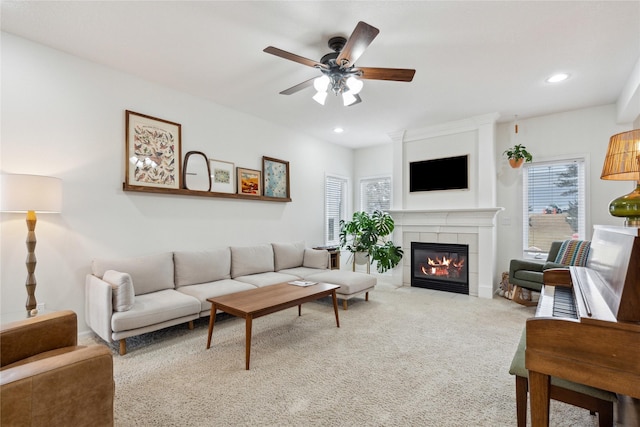 living room with carpet flooring, recessed lighting, a tile fireplace, and a ceiling fan