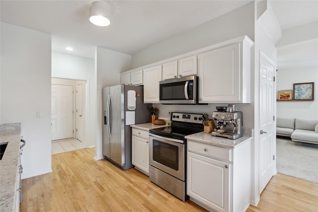 kitchen featuring white cabinets, light wood-style flooring, and stainless steel appliances