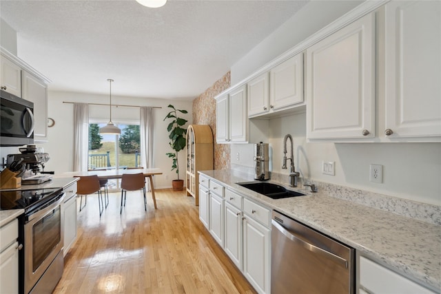 kitchen featuring a sink, stainless steel appliances, and white cabinets