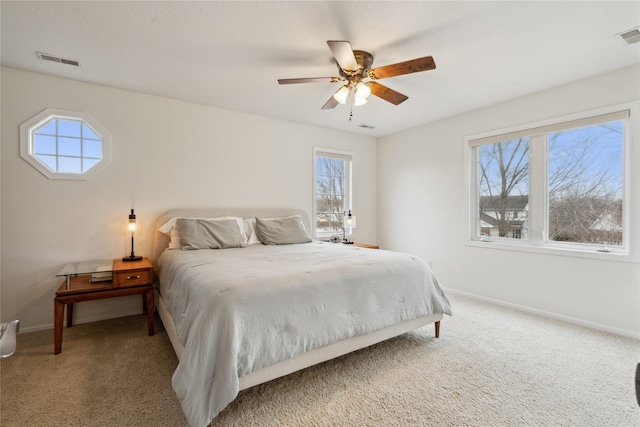 carpeted bedroom featuring baseboards, visible vents, and ceiling fan