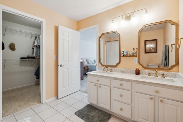 bathroom featuring a sink, a spacious closet, double vanity, and tile patterned flooring