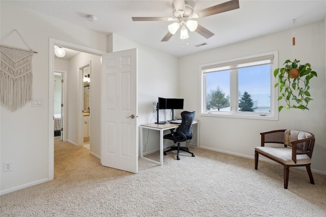 carpeted office space featuring baseboards, visible vents, and ceiling fan