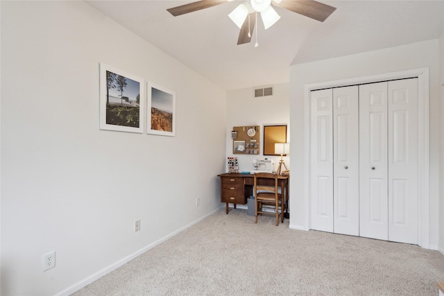 home office with visible vents, light colored carpet, a ceiling fan, and baseboards