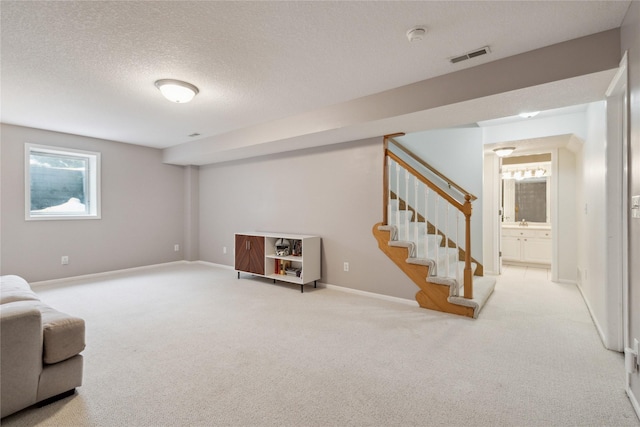 interior space with stairs, visible vents, carpet floors, and a textured ceiling