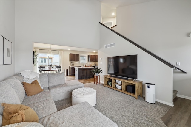 3325 Wolf Creek Rd SW, Bondurant, IA 50035 - living area with stairs, visible vents, light wood-type flooring, and baseboards