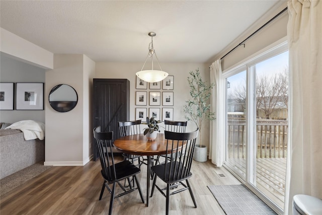 3325 Wolf Creek Rd SW, Bondurant, IA 50035 - dining space featuring baseboards and wood finished floors