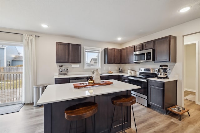 3325 Wolf Creek Rd SW, Bondurant, IA 50035 - kitchen featuring light countertops, dark brown cabinets, appliances with stainless steel finishes, and a breakfast bar