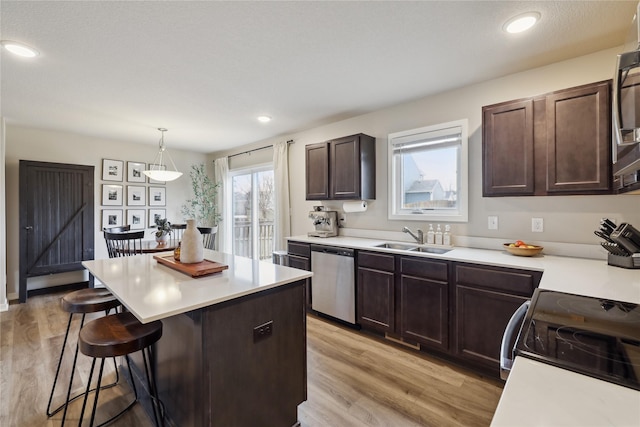 3325 Wolf Creek Rd SW, Bondurant, IA 50035 - kitchen featuring a sink, light countertops, a breakfast bar, and appliances with stainless steel finishes