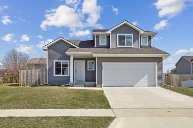 3325 Wolf Creek Rd SW, Bondurant, IA 50035 - traditional-style home with driveway, a front yard, an attached garage, and fence