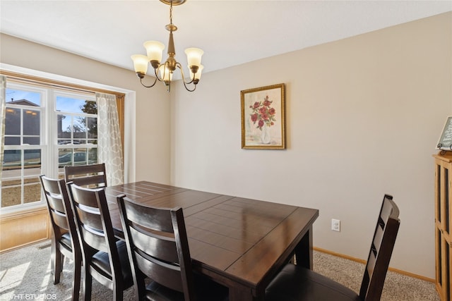 carpeted dining space with baseboards and an inviting chandelier