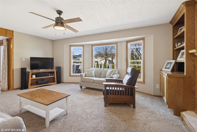 living room with light carpet, a ceiling fan, a wealth of natural light, and a textured ceiling