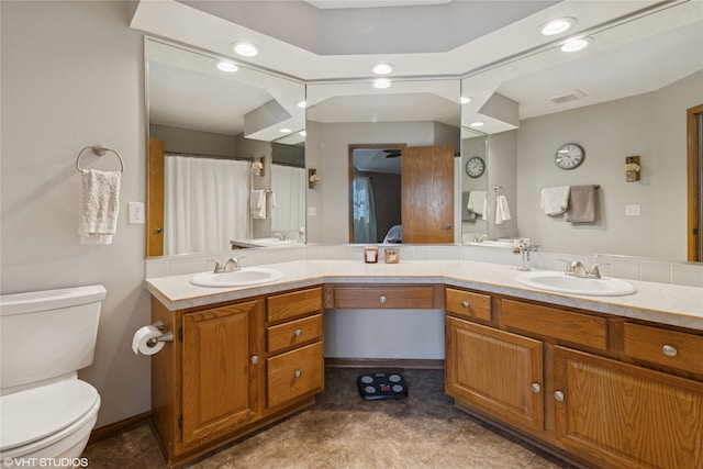 bathroom featuring double vanity, toilet, visible vents, and a sink