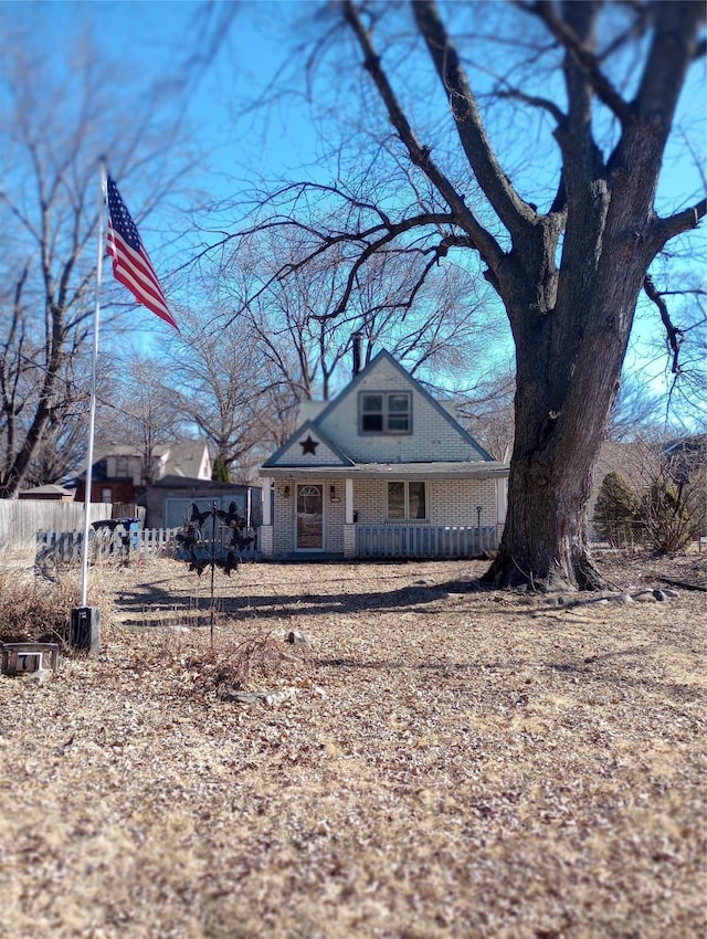 view of front of house with brick siding, covered porch, and a chimney