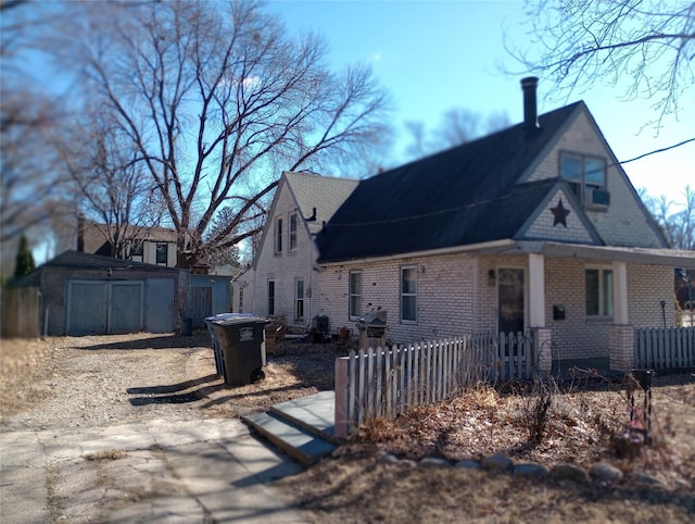 view of side of home with brick siding and fence