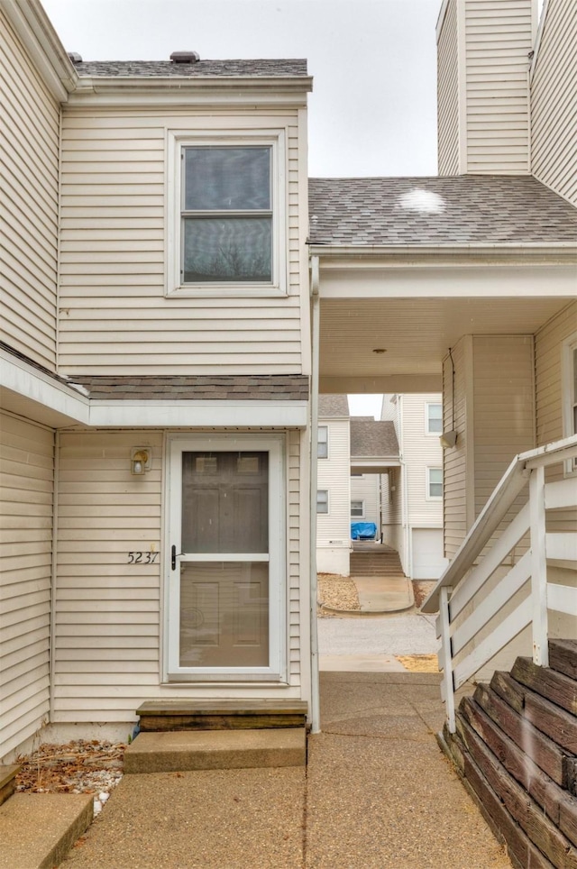 entrance to property with roof with shingles