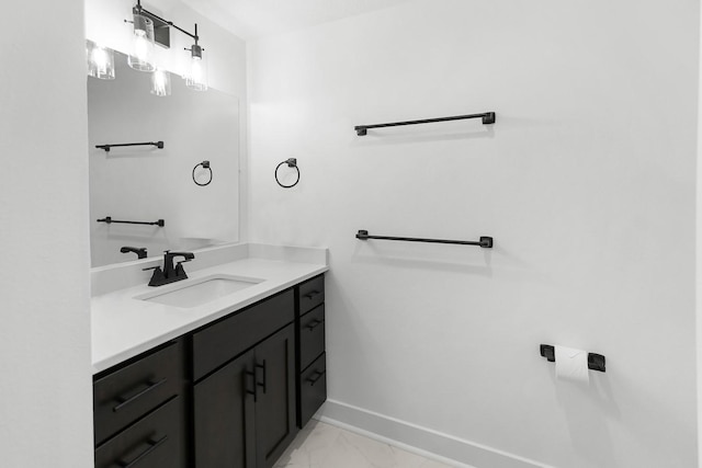 bathroom featuring marble finish floor, vanity, and baseboards