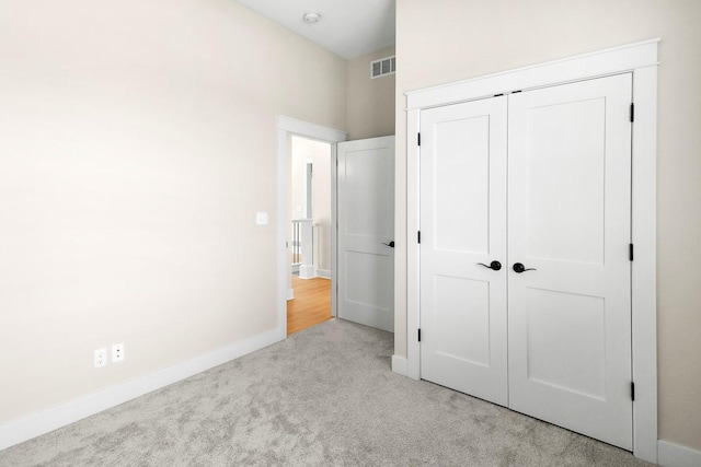 unfurnished bedroom featuring a closet, visible vents, carpet flooring, and baseboards