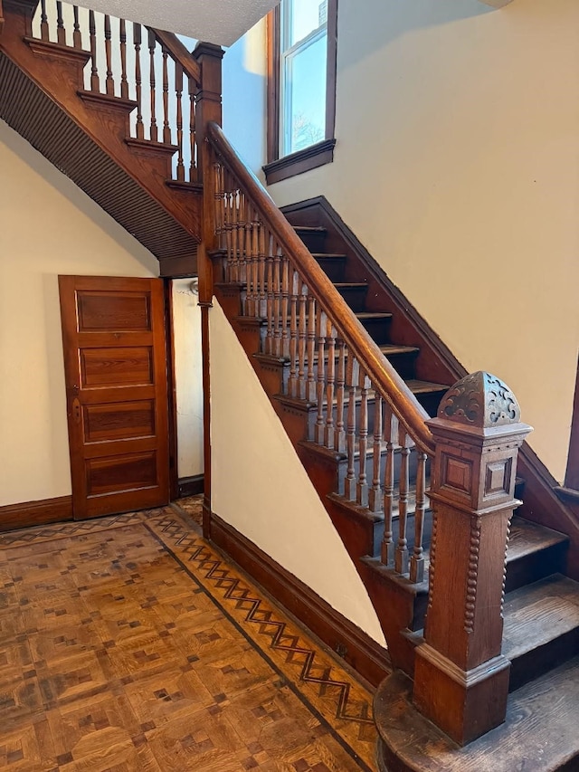 stairs featuring a high ceiling and baseboards