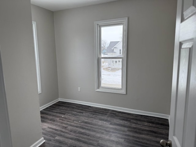 unfurnished room featuring dark wood-style floors and baseboards