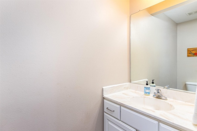 half bath with visible vents, toilet, and vanity