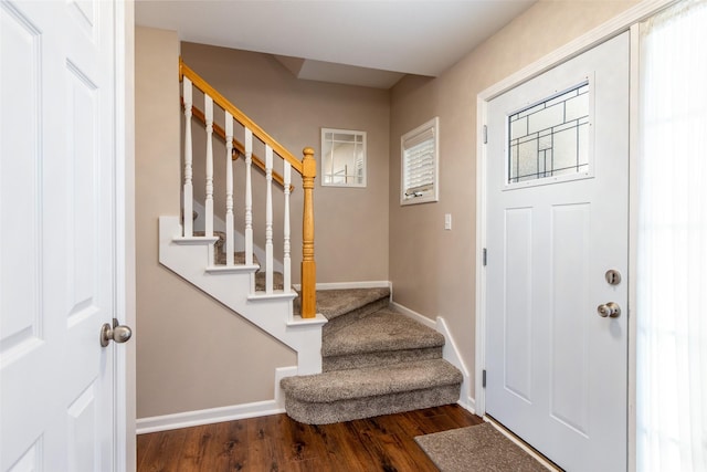 foyer entrance featuring stairway, wood finished floors, and baseboards