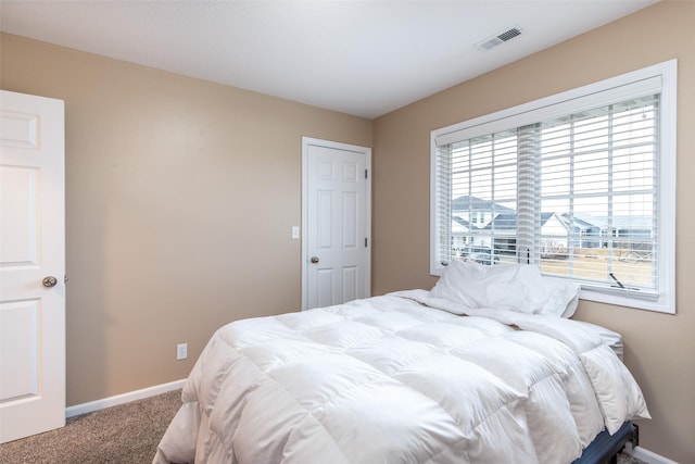 bedroom featuring visible vents, baseboards, and carpet