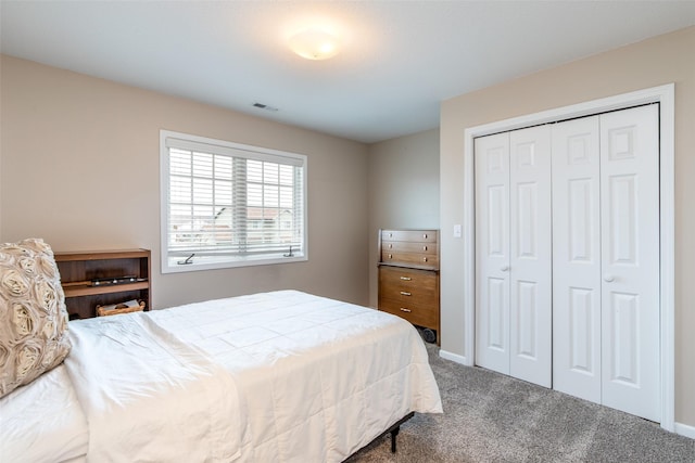 bedroom featuring baseboards, visible vents, carpet floors, and a closet