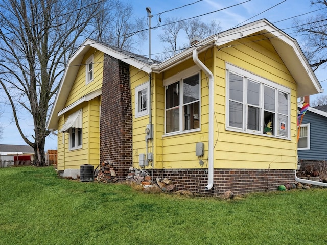 view of side of home with crawl space, central AC, a yard, and fence