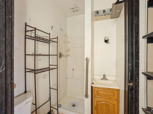 bathroom featuring visible vents, a shower stall, toilet, and vanity