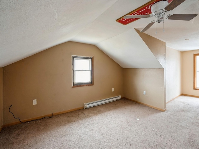 additional living space featuring lofted ceiling, a baseboard heating unit, a textured ceiling, carpet floors, and baseboards