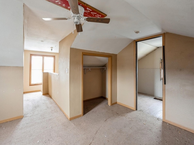 unfurnished bedroom featuring carpet, vaulted ceiling, a ceiling fan, and baseboards