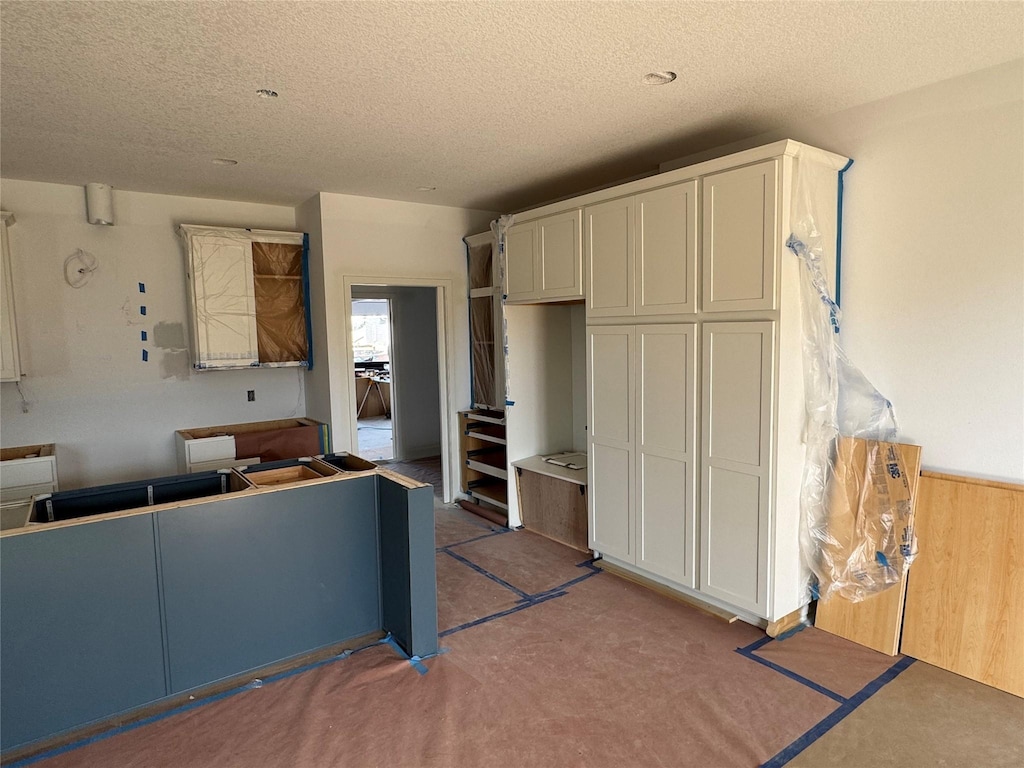 kitchen featuring white cabinetry and a textured ceiling