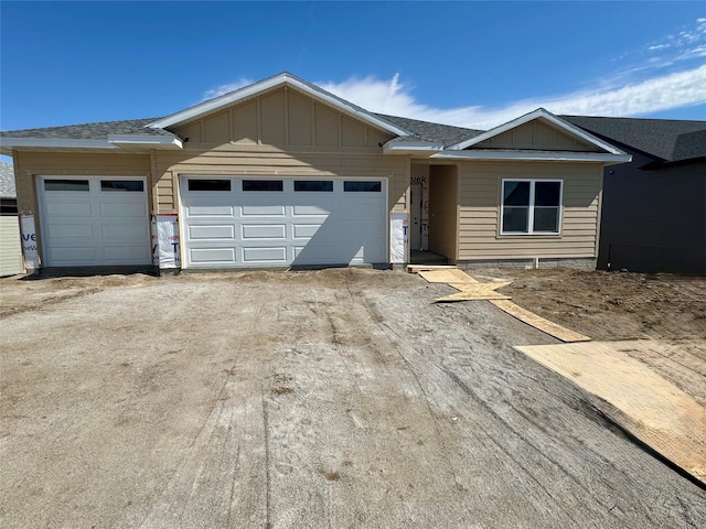 ranch-style house with board and batten siding, driveway, a garage, and a shingled roof