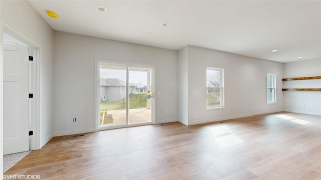 unfurnished living room featuring baseboards, recessed lighting, and light wood-type flooring