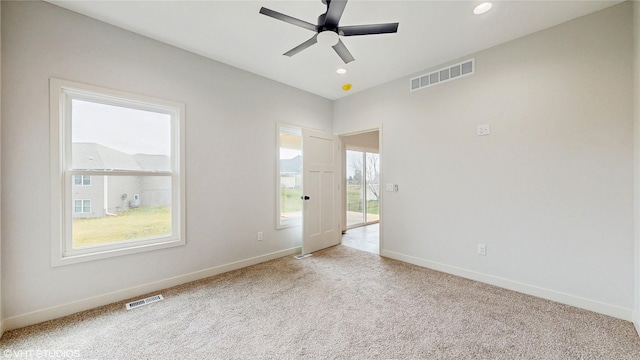 unfurnished room featuring baseboards, visible vents, and carpet