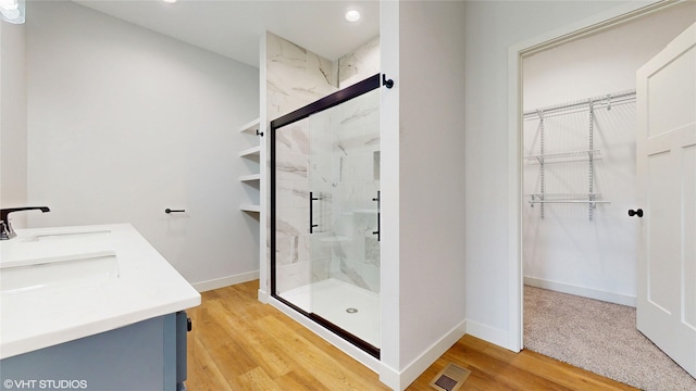 202 Meadowlark Dr, Monroe, IA 50170 - bathroom featuring a marble finish shower, a walk in closet, double vanity, baseboards, and recessed lighting